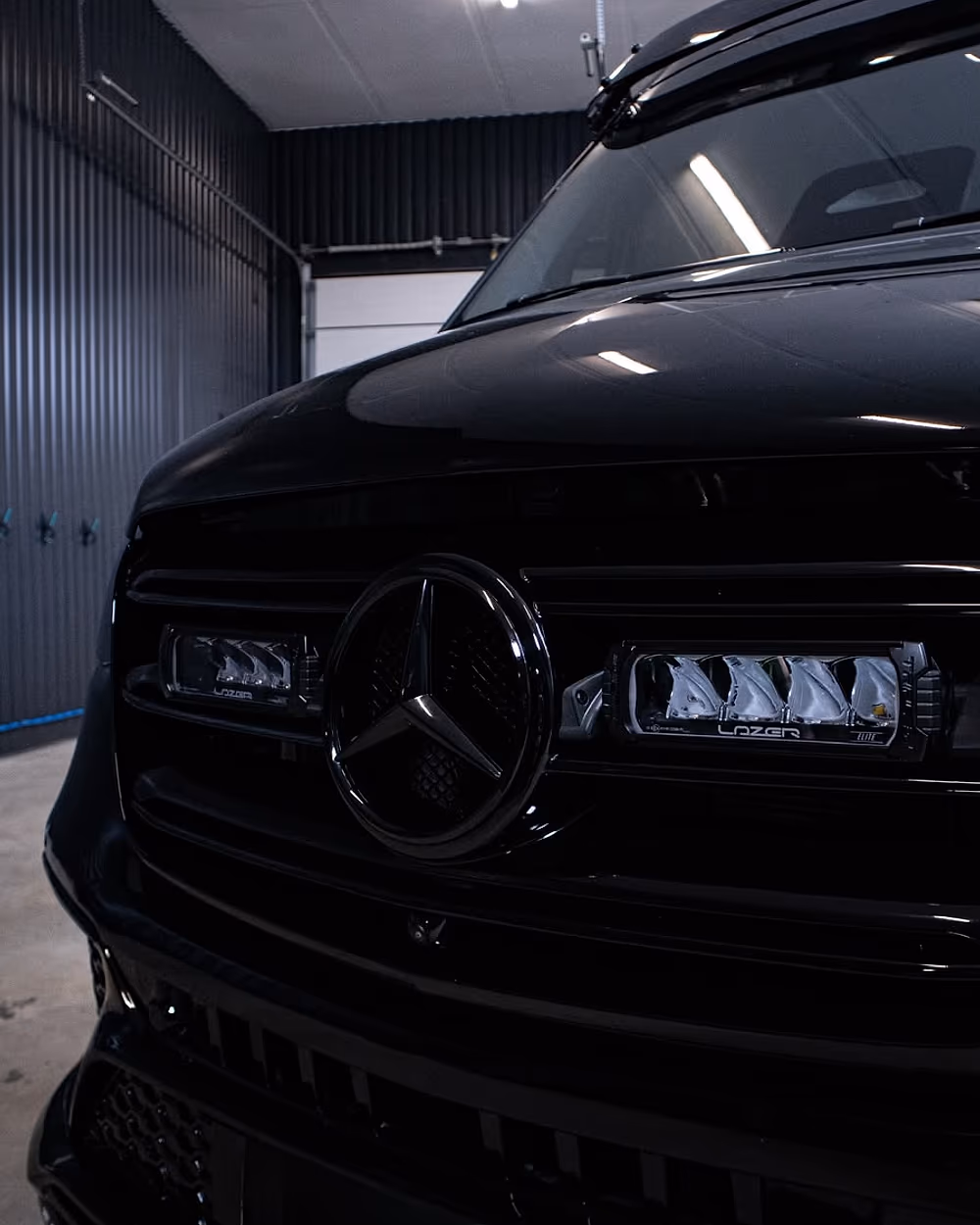 Tummaksi detailoitu ja kiillotettu auto hallissa